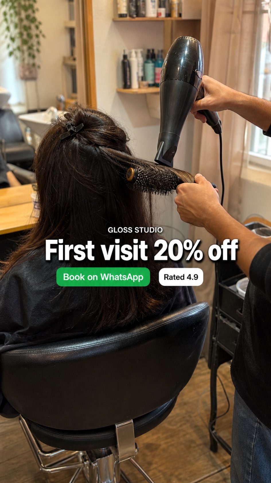 Candid 9:16 WhatsApp Status ad shot inside a small salon showing a stylist mid-blowout with the headline First visit 20% off, a green Book on WhatsApp button, and a Rated 4.9 badge in the central band
